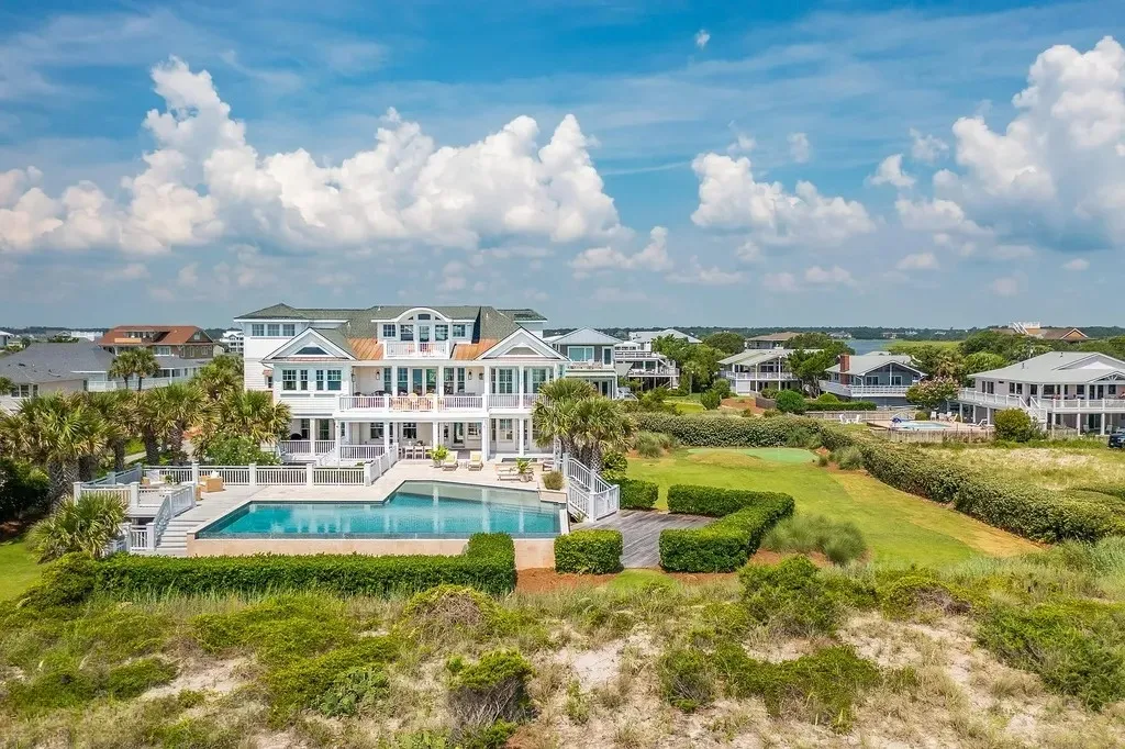 7 Cowrie Lane Home in Wrightsville Beach, North Carolina. Discover the epitome of luxurious coastal living at this expansive oceanfront estate in Wrightsville Beach. Set on nearly one acre of pristine land, this majestic property features a resort-style pool, lush landscaping, and private beach access. 