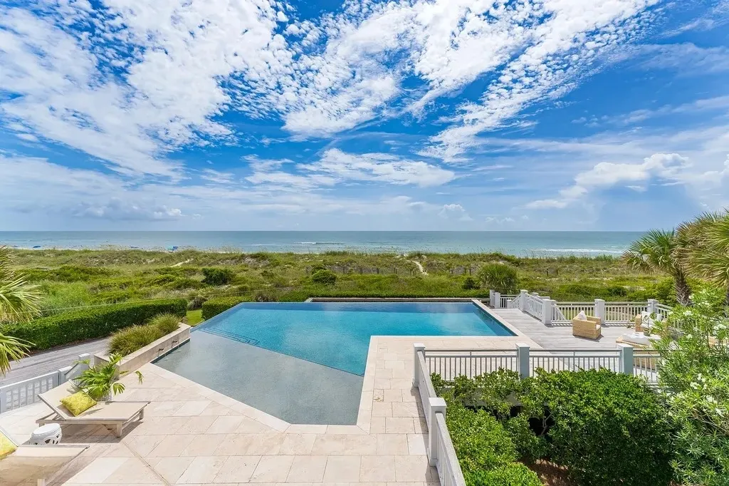 7 Cowrie Lane Home in Wrightsville Beach, North Carolina. Discover the epitome of luxurious coastal living at this expansive oceanfront estate in Wrightsville Beach. Set on nearly one acre of pristine land, this majestic property features a resort-style pool, lush landscaping, and private beach access. 