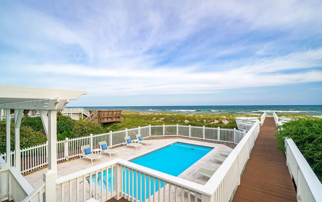 9721 Dolphin Ridge Road Home in Emerald Isle, North Carolina. Discover the epitome of oceanfront living in this exquisite Dolphin Ridge home, where luxury and customization intertwine to create a one-of-a-kind island sanctuary. Immerse yourself in the coastal lifestyle as you step into this beautifully furnished abode, thoughtfully tailored by the builder/owners to offer a seamless blend of comfort and sophistication.