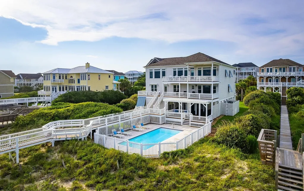 9721 Dolphin Ridge Road Home in Emerald Isle, North Carolina. Discover the epitome of oceanfront living in this exquisite Dolphin Ridge home, where luxury and customization intertwine to create a one-of-a-kind island sanctuary. Immerse yourself in the coastal lifestyle as you step into this beautifully furnished abode, thoughtfully tailored by the builder/owners to offer a seamless blend of comfort and sophistication.