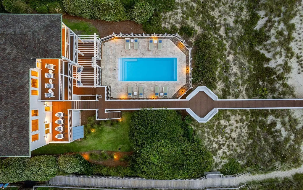 9721 Dolphin Ridge Road Home in Emerald Isle, North Carolina. Discover the epitome of oceanfront living in this exquisite Dolphin Ridge home, where luxury and customization intertwine to create a one-of-a-kind island sanctuary. Immerse yourself in the coastal lifestyle as you step into this beautifully furnished abode, thoughtfully tailored by the builder/owners to offer a seamless blend of comfort and sophistication.