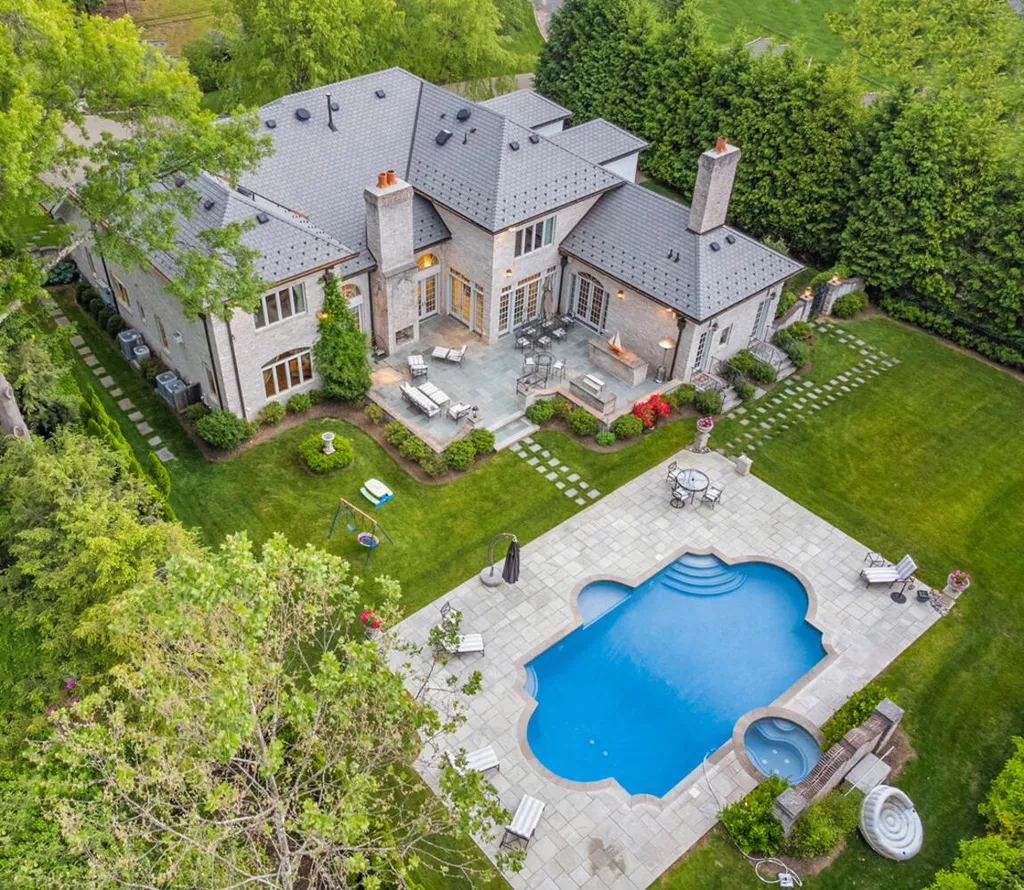 1 Lockhern Drive Home in Livingston Township, New Jersey. Step into the world of opulence with this custom-built, all-brick French Manor nestled on a tranquil cul-de-sac. The mature landscaping, saltwater pool, hot tub, limestone pool deck, and outdoor fireplace spanning 30 feet create a private oasis. Inside, discover a grand entrance hall leading to a stunning living room with a soaring 2-story ceiling, fireplace, and French doors opening to the patio and pool.