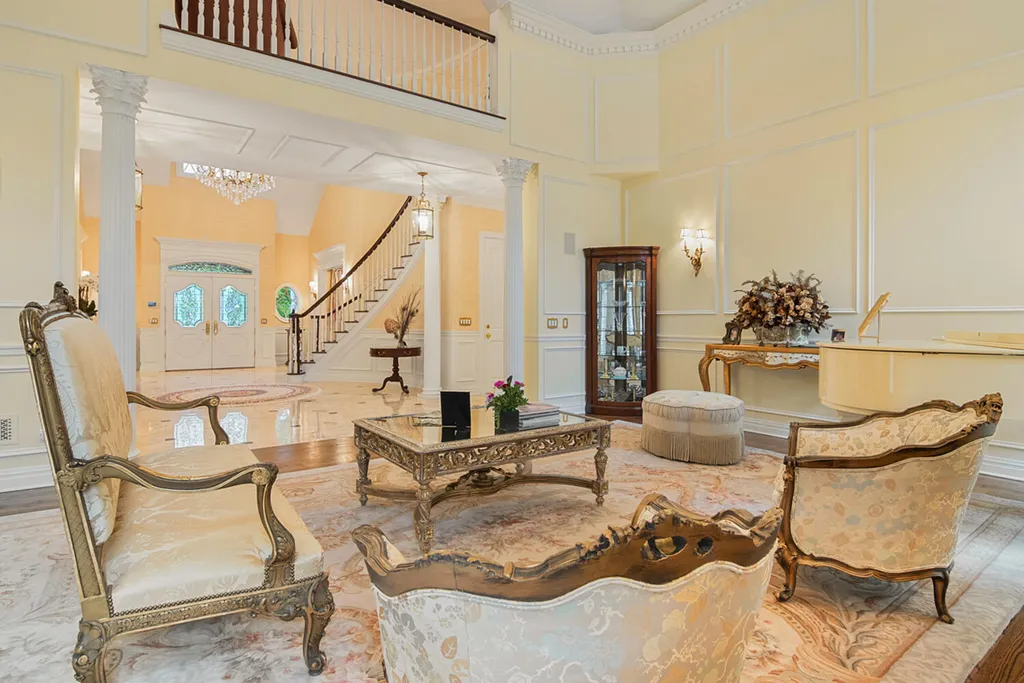 1 Lockhern Drive Home in Livingston Township, New Jersey. Step into the world of opulence with this custom-built, all-brick French Manor nestled on a tranquil cul-de-sac. The mature landscaping, saltwater pool, hot tub, limestone pool deck, and outdoor fireplace spanning 30 feet create a private oasis. Inside, discover a grand entrance hall leading to a stunning living room with a soaring 2-story ceiling, fireplace, and French doors opening to the patio and pool.