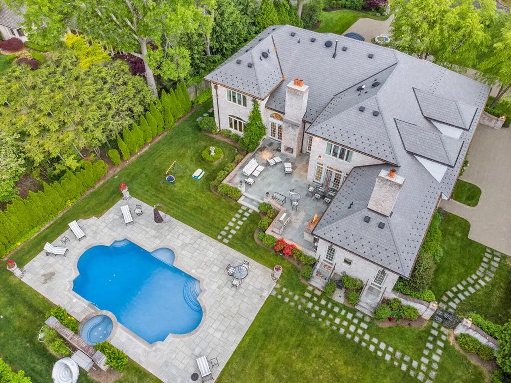 1 Lockhern Drive Home in Livingston Township, New Jersey. Step into the world of opulence with this custom-built, all-brick French Manor nestled on a tranquil cul-de-sac. The mature landscaping, saltwater pool, hot tub, limestone pool deck, and outdoor fireplace spanning 30 feet create a private oasis. Inside, discover a grand entrance hall leading to a stunning living room with a soaring 2-story ceiling, fireplace, and French doors opening to the patio and pool.