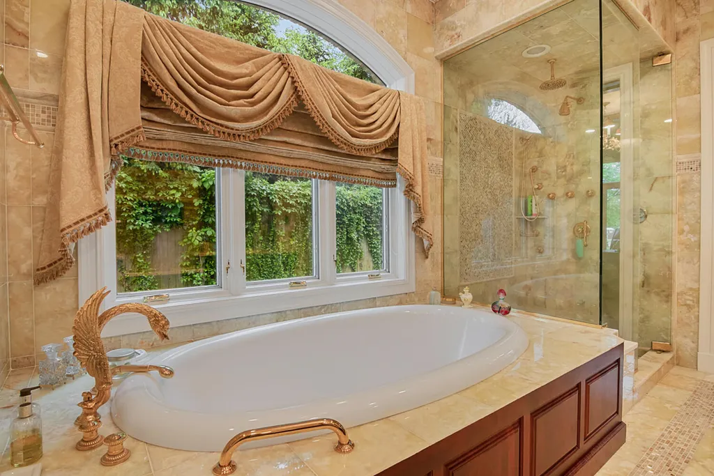 1 Lockhern Drive Home in Livingston Township, New Jersey. Step into the world of opulence with this custom-built, all-brick French Manor nestled on a tranquil cul-de-sac. The mature landscaping, saltwater pool, hot tub, limestone pool deck, and outdoor fireplace spanning 30 feet create a private oasis. Inside, discover a grand entrance hall leading to a stunning living room with a soaring 2-story ceiling, fireplace, and French doors opening to the patio and pool.