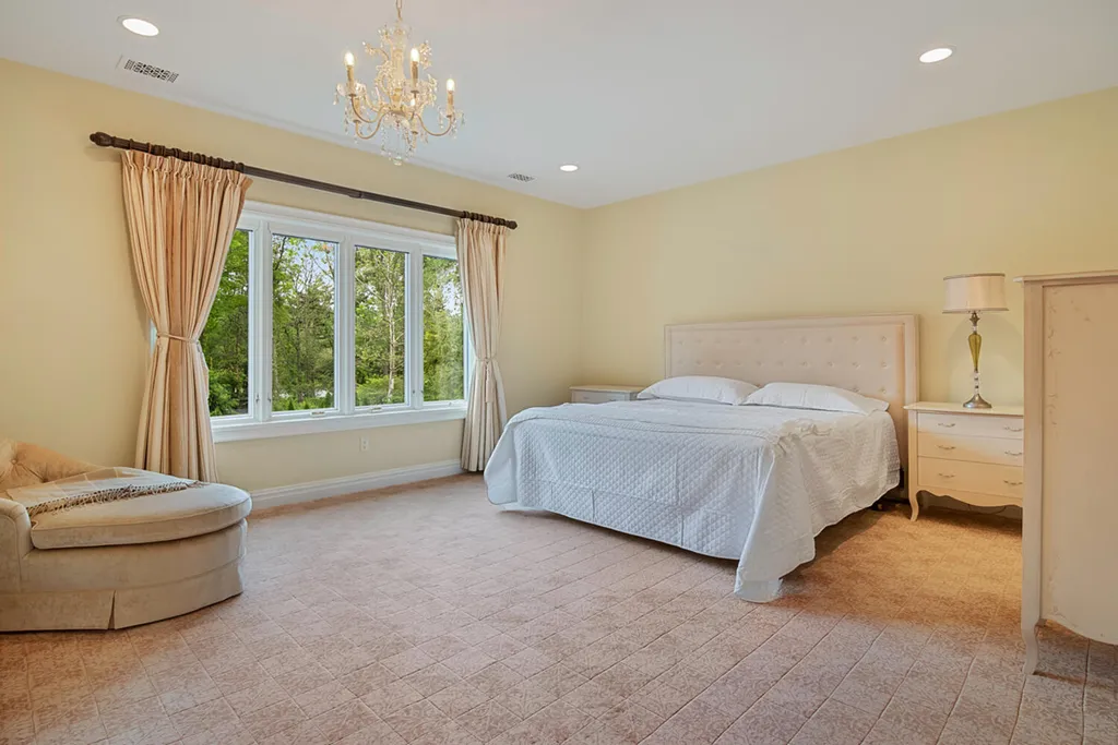 1 Lockhern Drive Home in Livingston Township, New Jersey. Step into the world of opulence with this custom-built, all-brick French Manor nestled on a tranquil cul-de-sac. The mature landscaping, saltwater pool, hot tub, limestone pool deck, and outdoor fireplace spanning 30 feet create a private oasis. Inside, discover a grand entrance hall leading to a stunning living room with a soaring 2-story ceiling, fireplace, and French doors opening to the patio and pool.