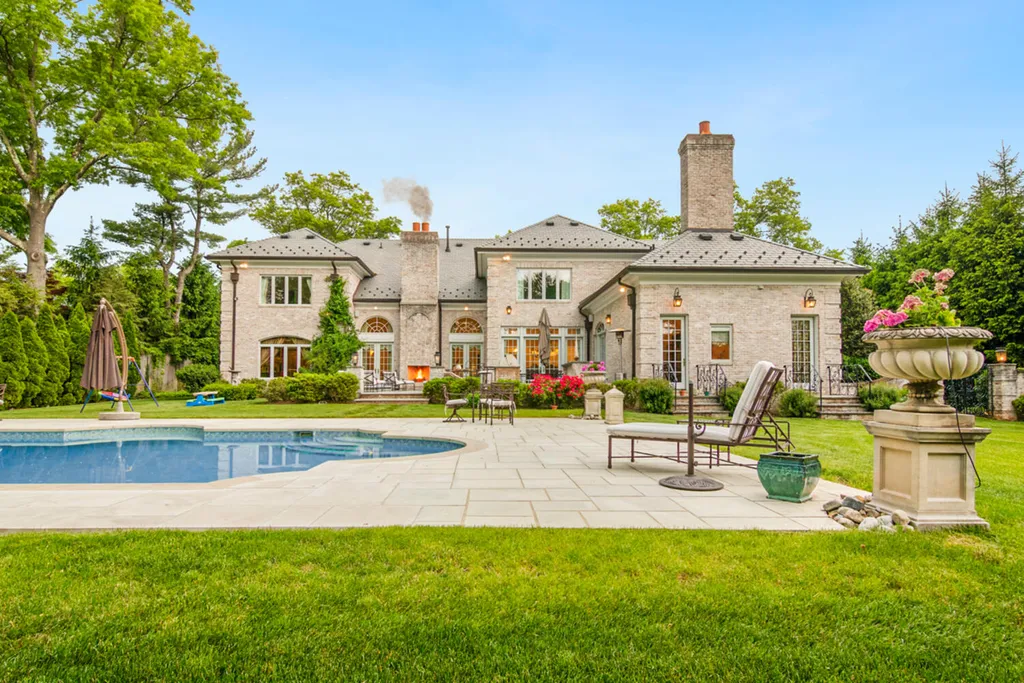 1 Lockhern Drive Home in Livingston Township, New Jersey. Step into the world of opulence with this custom-built, all-brick French Manor nestled on a tranquil cul-de-sac. The mature landscaping, saltwater pool, hot tub, limestone pool deck, and outdoor fireplace spanning 30 feet create a private oasis. Inside, discover a grand entrance hall leading to a stunning living room with a soaring 2-story ceiling, fireplace, and French doors opening to the patio and pool.