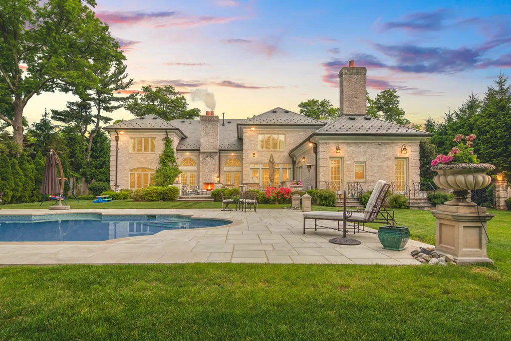 1 Lockhern Drive Home in Livingston Township, New Jersey. Step into the world of opulence with this custom-built, all-brick French Manor nestled on a tranquil cul-de-sac. The mature landscaping, saltwater pool, hot tub, limestone pool deck, and outdoor fireplace spanning 30 feet create a private oasis. Inside, discover a grand entrance hall leading to a stunning living room with a soaring 2-story ceiling, fireplace, and French doors opening to the patio and pool.