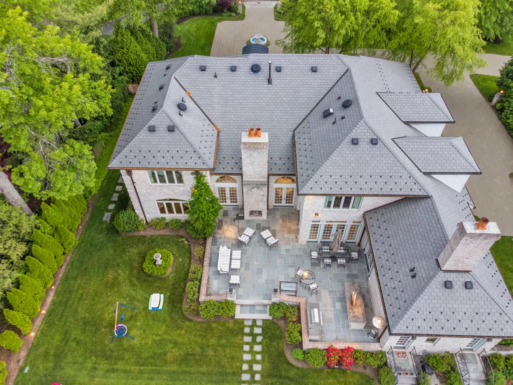1 Lockhern Drive Home in Livingston Township, New Jersey. Step into the world of opulence with this custom-built, all-brick French Manor nestled on a tranquil cul-de-sac. The mature landscaping, saltwater pool, hot tub, limestone pool deck, and outdoor fireplace spanning 30 feet create a private oasis. Inside, discover a grand entrance hall leading to a stunning living room with a soaring 2-story ceiling, fireplace, and French doors opening to the patio and pool.