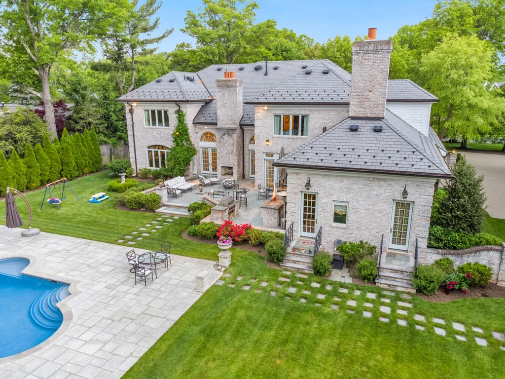 1 Lockhern Drive Home in Livingston Township, New Jersey. Step into the world of opulence with this custom-built, all-brick French Manor nestled on a tranquil cul-de-sac. The mature landscaping, saltwater pool, hot tub, limestone pool deck, and outdoor fireplace spanning 30 feet create a private oasis. Inside, discover a grand entrance hall leading to a stunning living room with a soaring 2-story ceiling, fireplace, and French doors opening to the patio and pool.