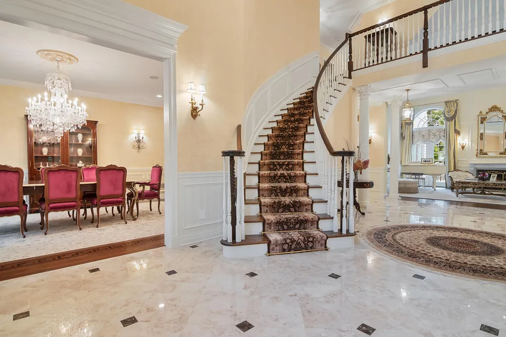 1 Lockhern Drive Home in Livingston Township, New Jersey. Step into the world of opulence with this custom-built, all-brick French Manor nestled on a tranquil cul-de-sac. The mature landscaping, saltwater pool, hot tub, limestone pool deck, and outdoor fireplace spanning 30 feet create a private oasis. Inside, discover a grand entrance hall leading to a stunning living room with a soaring 2-story ceiling, fireplace, and French doors opening to the patio and pool.