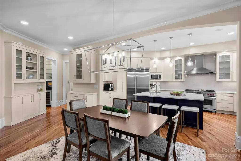 11717 Smart Lane Home in Charlotte, North Carolina. Experience the epitome of modern elegance in this gated estate with breathtaking views of the signature 13th hole from nearly every room and the stunning 48-ft pool. Designed by Christopher Phelps and crafted by Simonini, this home boasts an open floor plan, tall windows, curved walls, and a sweeping custom staircase inspired by Art Deco design.