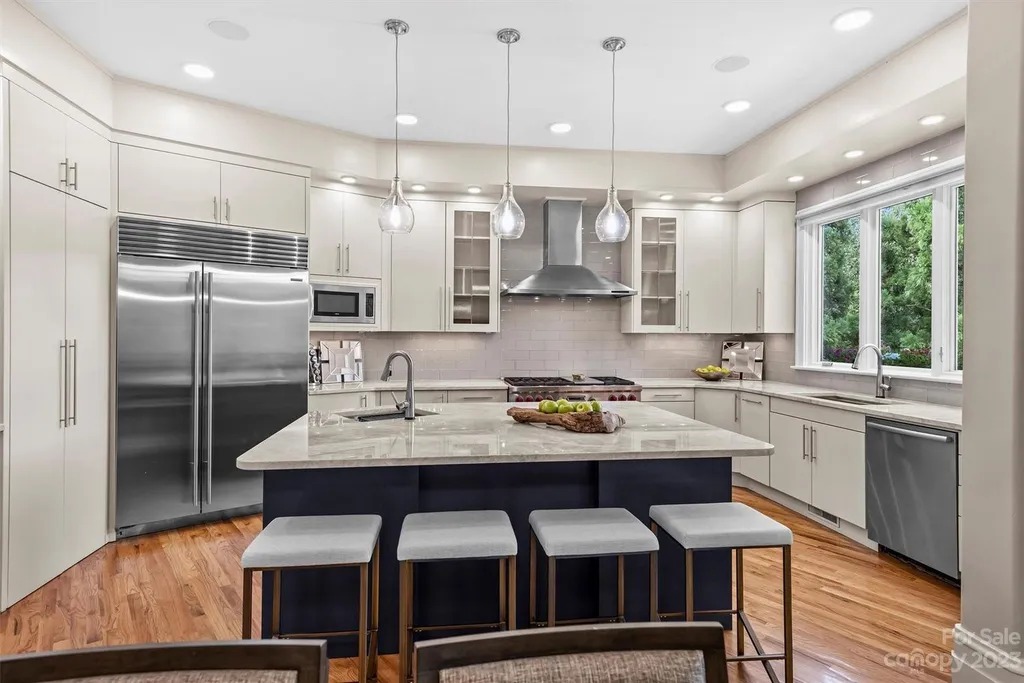 11717 Smart Lane Home in Charlotte, North Carolina. Experience the epitome of modern elegance in this gated estate with breathtaking views of the signature 13th hole from nearly every room and the stunning 48-ft pool. Designed by Christopher Phelps and crafted by Simonini, this home boasts an open floor plan, tall windows, curved walls, and a sweeping custom staircase inspired by Art Deco design.