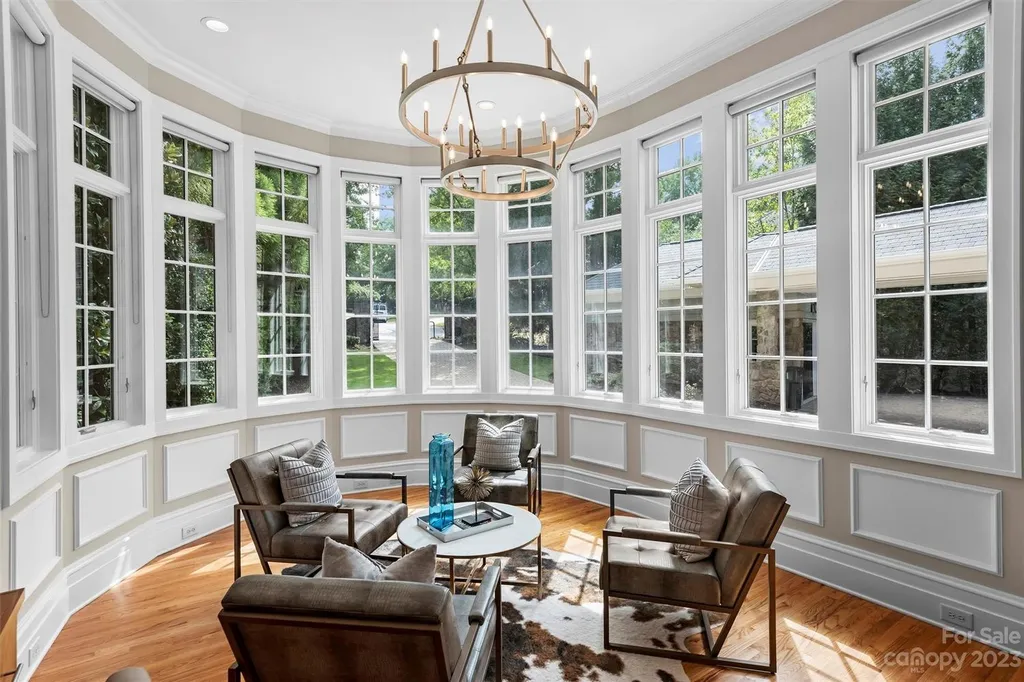 11717 Smart Lane Home in Charlotte, North Carolina. Experience the epitome of modern elegance in this gated estate with breathtaking views of the signature 13th hole from nearly every room and the stunning 48-ft pool. Designed by Christopher Phelps and crafted by Simonini, this home boasts an open floor plan, tall windows, curved walls, and a sweeping custom staircase inspired by Art Deco design.
