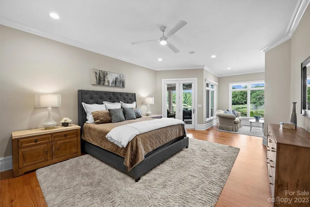 11717 Smart Lane Home in Charlotte, North Carolina. Experience the epitome of modern elegance in this gated estate with breathtaking views of the signature 13th hole from nearly every room and the stunning 48-ft pool. Designed by Christopher Phelps and crafted by Simonini, this home boasts an open floor plan, tall windows, curved walls, and a sweeping custom staircase inspired by Art Deco design.