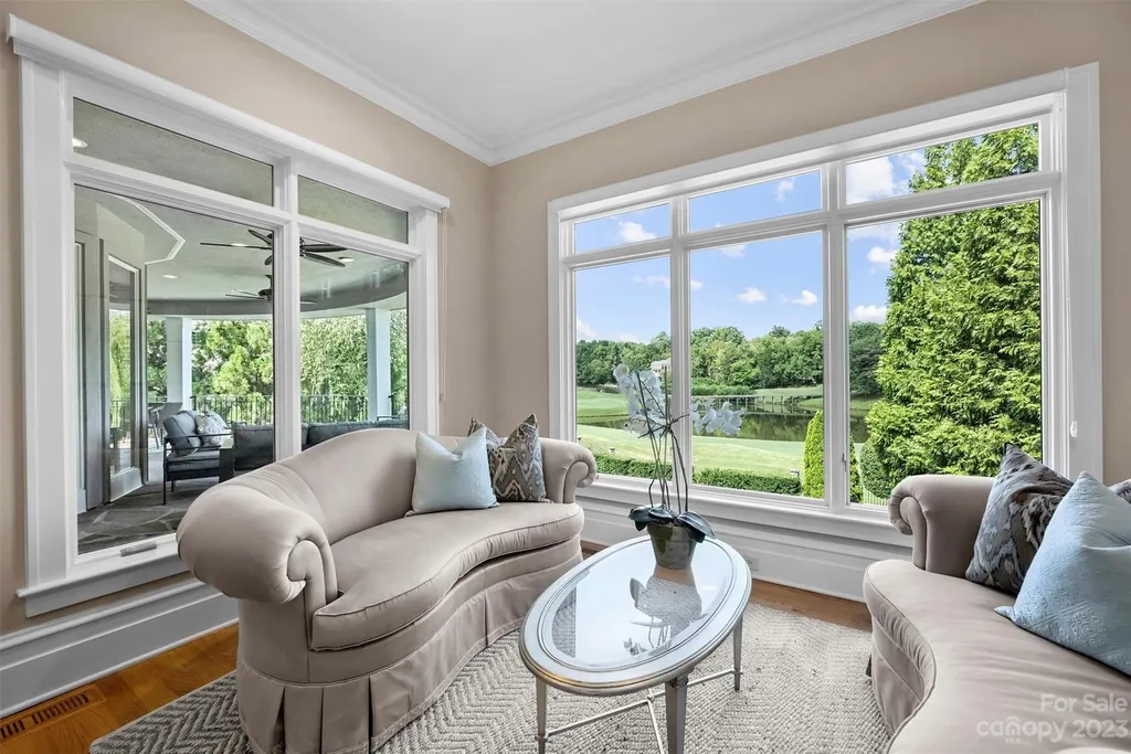 11717 Smart Lane Home in Charlotte, North Carolina. Experience the epitome of modern elegance in this gated estate with breathtaking views of the signature 13th hole from nearly every room and the stunning 48-ft pool. Designed by Christopher Phelps and crafted by Simonini, this home boasts an open floor plan, tall windows, curved walls, and a sweeping custom staircase inspired by Art Deco design.