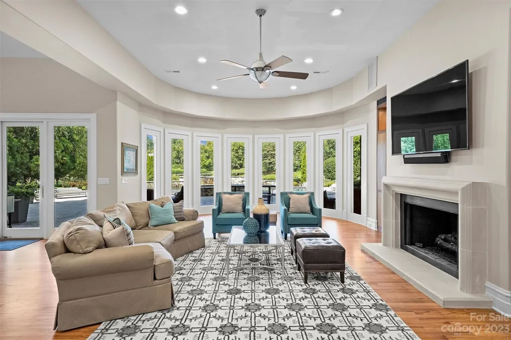 11717 Smart Lane Home in Charlotte, North Carolina. Experience the epitome of modern elegance in this gated estate with breathtaking views of the signature 13th hole from nearly every room and the stunning 48-ft pool. Designed by Christopher Phelps and crafted by Simonini, this home boasts an open floor plan, tall windows, curved walls, and a sweeping custom staircase inspired by Art Deco design.