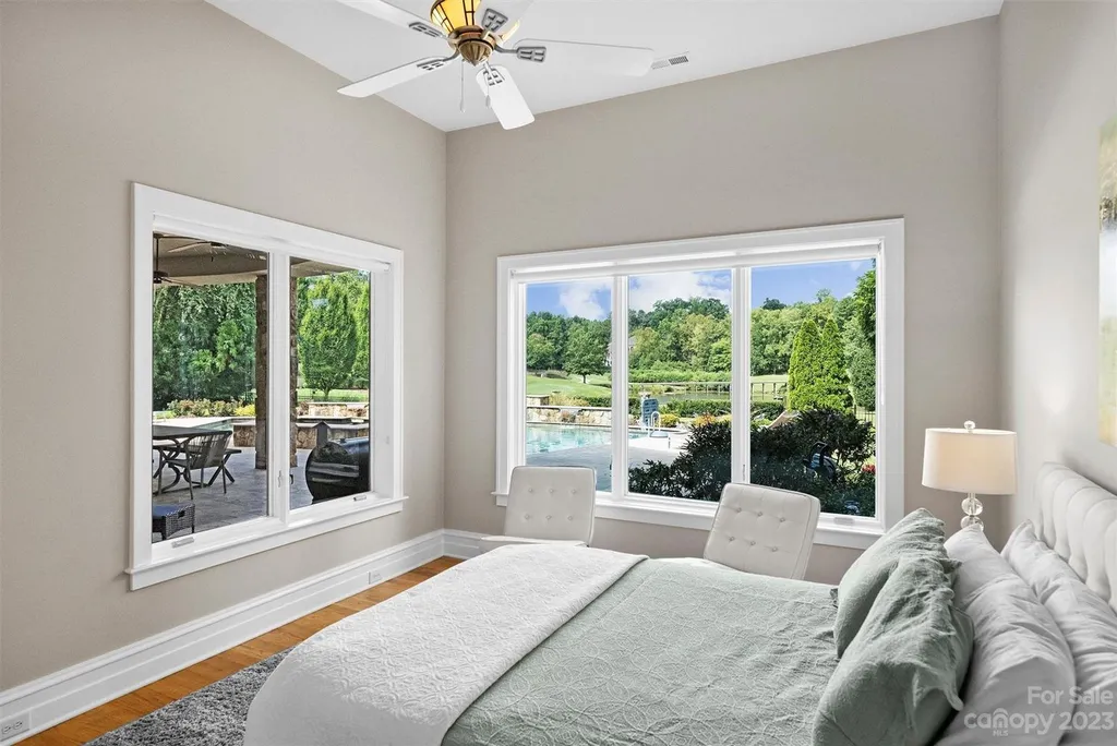 11717 Smart Lane Home in Charlotte, North Carolina. Experience the epitome of modern elegance in this gated estate with breathtaking views of the signature 13th hole from nearly every room and the stunning 48-ft pool. Designed by Christopher Phelps and crafted by Simonini, this home boasts an open floor plan, tall windows, curved walls, and a sweeping custom staircase inspired by Art Deco design.