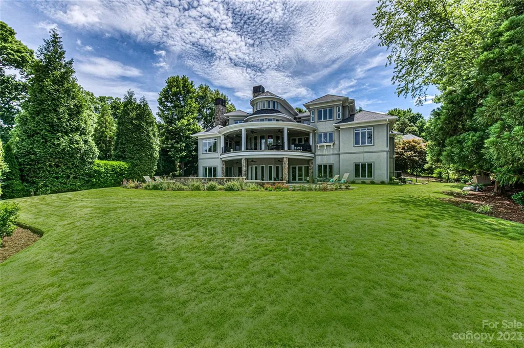 11717 Smart Lane Home in Charlotte, North Carolina. Experience the epitome of modern elegance in this gated estate with breathtaking views of the signature 13th hole from nearly every room and the stunning 48-ft pool. Designed by Christopher Phelps and crafted by Simonini, this home boasts an open floor plan, tall windows, curved walls, and a sweeping custom staircase inspired by Art Deco design.