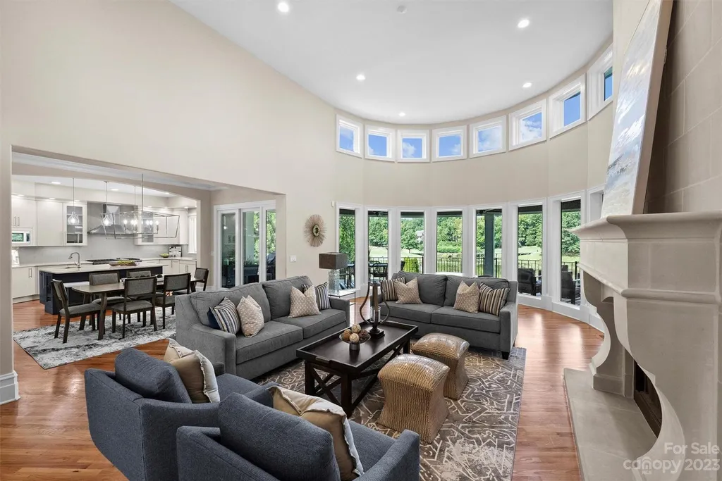 11717 Smart Lane Home in Charlotte, North Carolina. Experience the epitome of modern elegance in this gated estate with breathtaking views of the signature 13th hole from nearly every room and the stunning 48-ft pool. Designed by Christopher Phelps and crafted by Simonini, this home boasts an open floor plan, tall windows, curved walls, and a sweeping custom staircase inspired by Art Deco design.