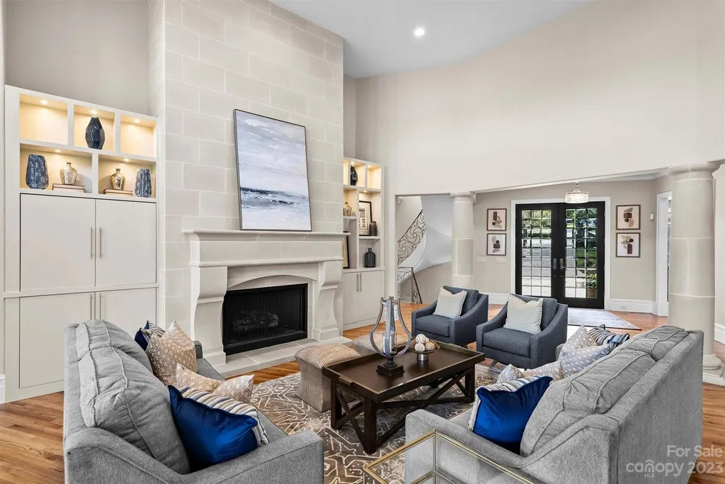 11717 Smart Lane Home in Charlotte, North Carolina. Experience the epitome of modern elegance in this gated estate with breathtaking views of the signature 13th hole from nearly every room and the stunning 48-ft pool. Designed by Christopher Phelps and crafted by Simonini, this home boasts an open floor plan, tall windows, curved walls, and a sweeping custom staircase inspired by Art Deco design.