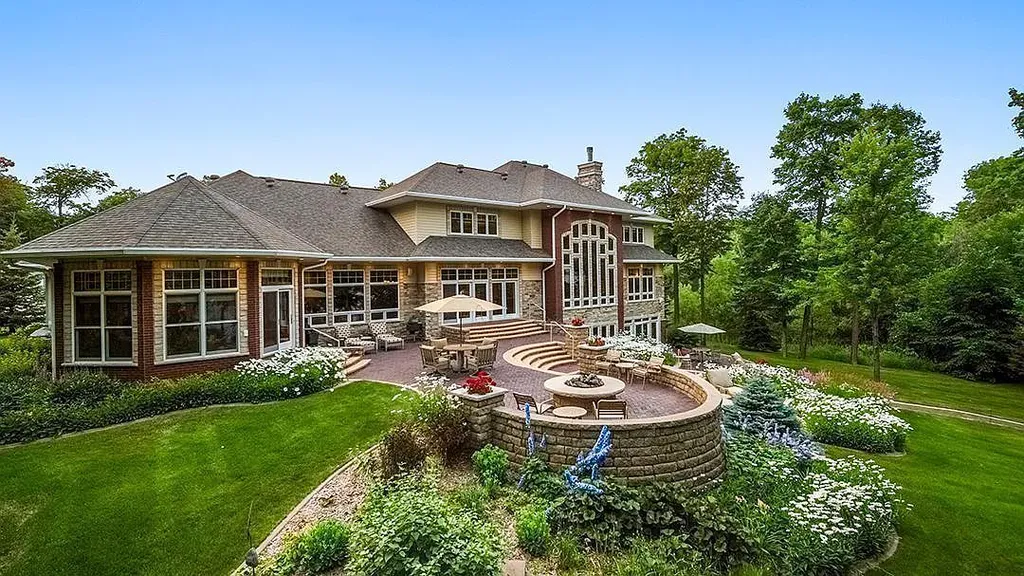 This stunning lakefront home is located in Cormorant Park Place, a premier lakeshore community. It has 6 bedrooms, 5 bathrooms, and 9,595 square feet of living space. The home features soaring ceilings, grand windows, hand-hewn imported wood, and hand-picked stone surfaces. It also has a private terrace with a fire pit, and access to the community's amenities, including a clubhouse, heated pool, swim beach, and slip system.