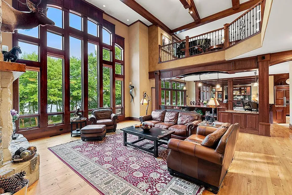 This stunning lakefront home is located in Cormorant Park Place, a premier lakeshore community. It has 6 bedrooms, 5 bathrooms, and 9,595 square feet of living space. The home features soaring ceilings, grand windows, hand-hewn imported wood, and hand-picked stone surfaces. It also has a private terrace with a fire pit, and access to the community's amenities, including a clubhouse, heated pool, swim beach, and slip system.