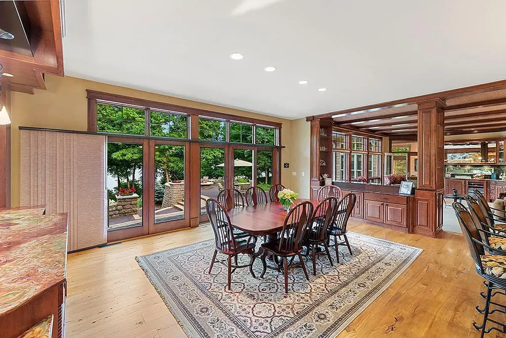This stunning lakefront home is located in Cormorant Park Place, a premier lakeshore community. It has 6 bedrooms, 5 bathrooms, and 9,595 square feet of living space. The home features soaring ceilings, grand windows, hand-hewn imported wood, and hand-picked stone surfaces. It also has a private terrace with a fire pit, and access to the community's amenities, including a clubhouse, heated pool, swim beach, and slip system.