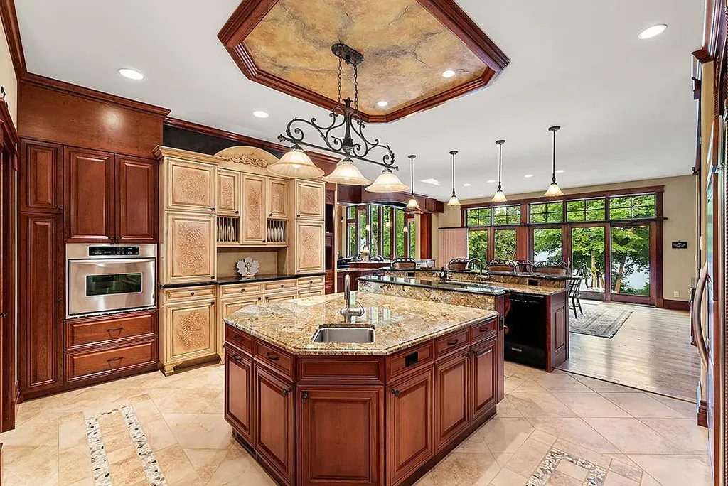 This stunning lakefront home is located in Cormorant Park Place, a premier lakeshore community. It has 6 bedrooms, 5 bathrooms, and 9,595 square feet of living space. The home features soaring ceilings, grand windows, hand-hewn imported wood, and hand-picked stone surfaces. It also has a private terrace with a fire pit, and access to the community's amenities, including a clubhouse, heated pool, swim beach, and slip system.