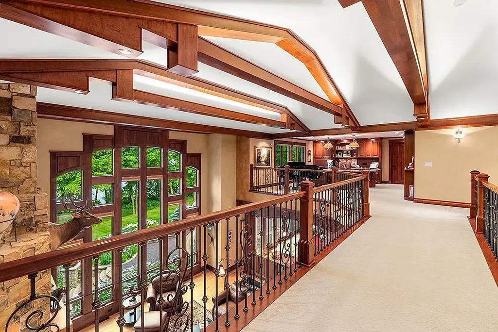 This stunning lakefront home is located in Cormorant Park Place, a premier lakeshore community. It has 6 bedrooms, 5 bathrooms, and 9,595 square feet of living space. The home features soaring ceilings, grand windows, hand-hewn imported wood, and hand-picked stone surfaces. It also has a private terrace with a fire pit, and access to the community's amenities, including a clubhouse, heated pool, swim beach, and slip system.