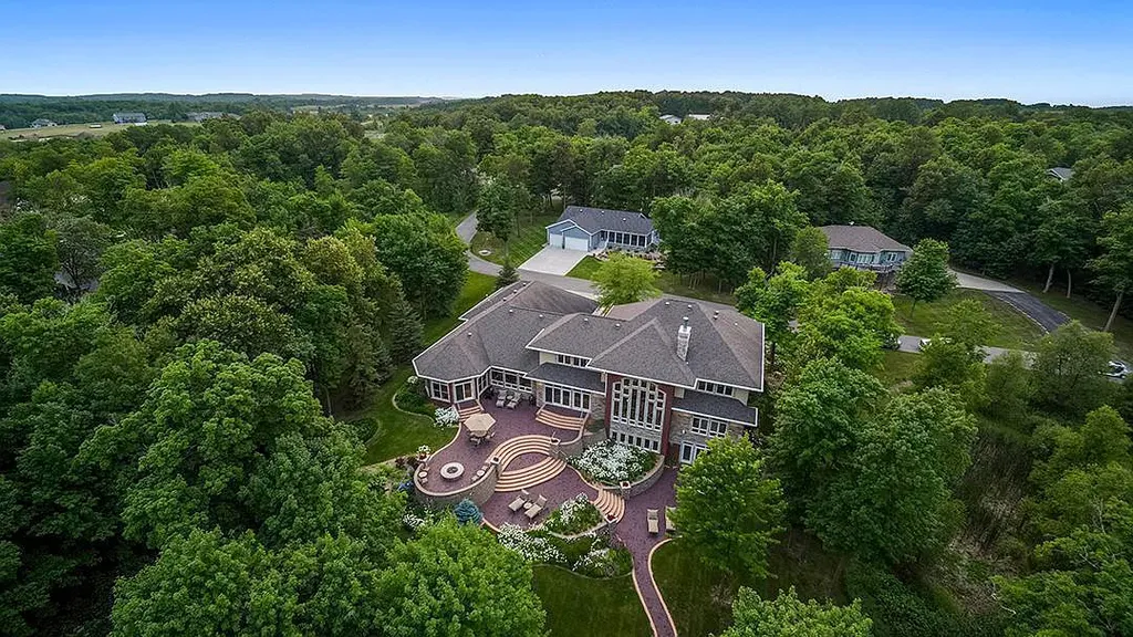 This stunning lakefront home is located in Cormorant Park Place, a premier lakeshore community. It has 6 bedrooms, 5 bathrooms, and 9,595 square feet of living space. The home features soaring ceilings, grand windows, hand-hewn imported wood, and hand-picked stone surfaces. It also has a private terrace with a fire pit, and access to the community's amenities, including a clubhouse, heated pool, swim beach, and slip system.
