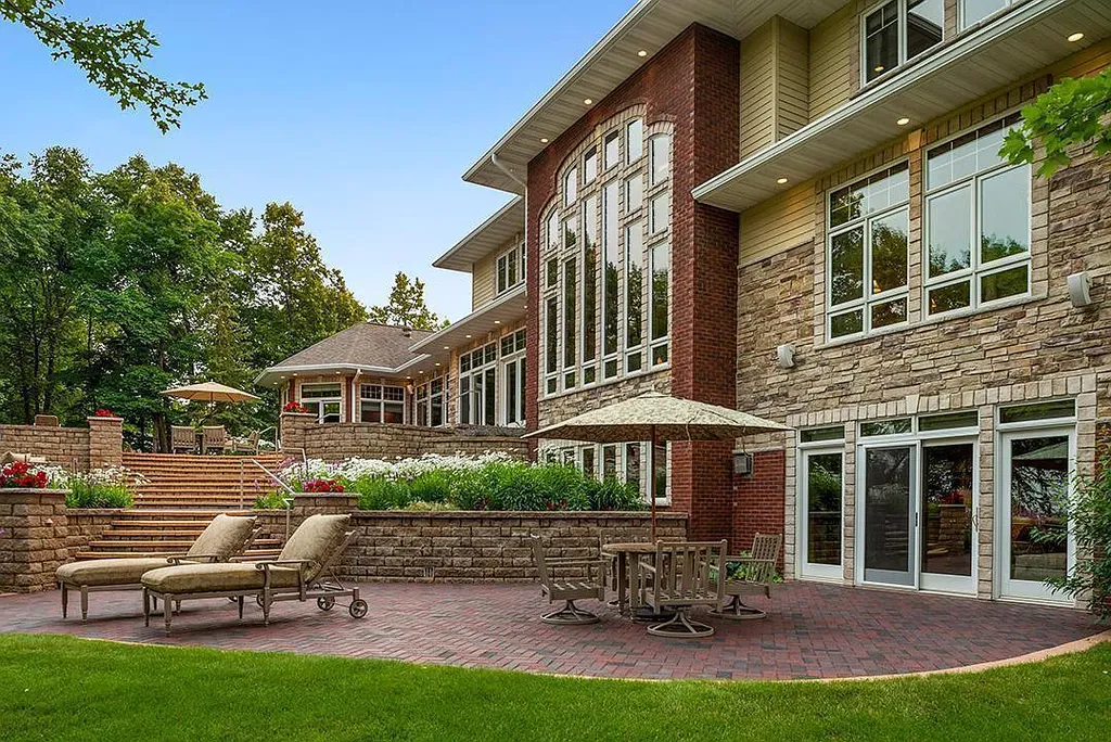 This stunning lakefront home is located in Cormorant Park Place, a premier lakeshore community. It has 6 bedrooms, 5 bathrooms, and 9,595 square feet of living space. The home features soaring ceilings, grand windows, hand-hewn imported wood, and hand-picked stone surfaces. It also has a private terrace with a fire pit, and access to the community's amenities, including a clubhouse, heated pool, swim beach, and slip system.
