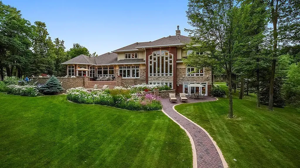 This stunning lakefront home is located in Cormorant Park Place, a premier lakeshore community. It has 6 bedrooms, 5 bathrooms, and 9,595 square feet of living space. The home features soaring ceilings, grand windows, hand-hewn imported wood, and hand-picked stone surfaces. It also has a private terrace with a fire pit, and access to the community's amenities, including a clubhouse, heated pool, swim beach, and slip system.