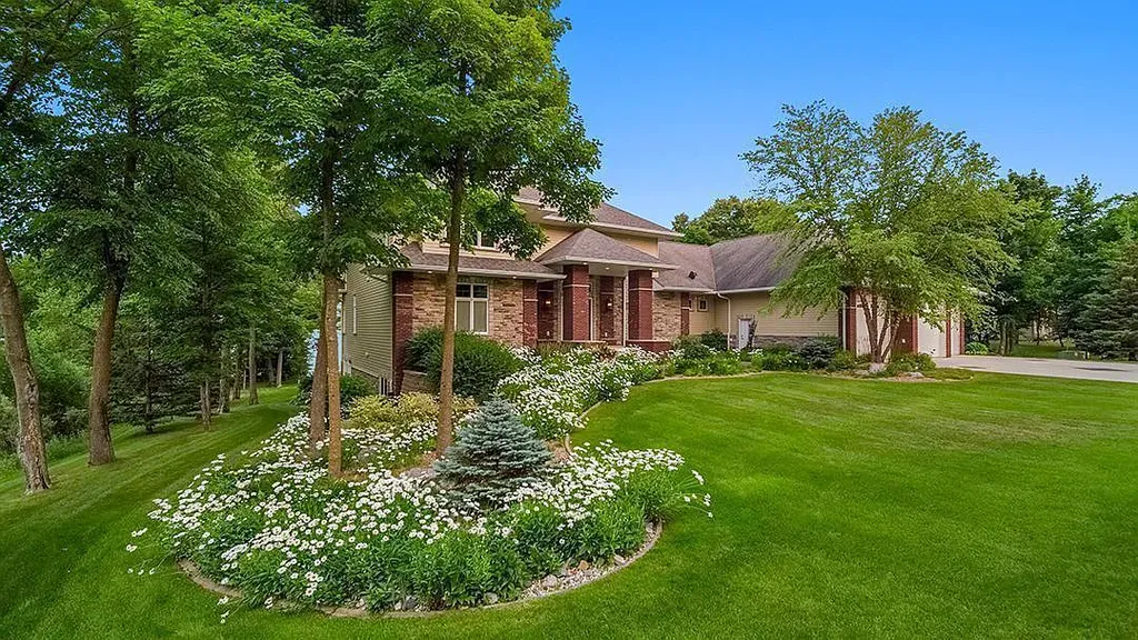 This stunning lakefront home is located in Cormorant Park Place, a premier lakeshore community. It has 6 bedrooms, 5 bathrooms, and 9,595 square feet of living space. The home features soaring ceilings, grand windows, hand-hewn imported wood, and hand-picked stone surfaces. It also has a private terrace with a fire pit, and access to the community's amenities, including a clubhouse, heated pool, swim beach, and slip system.
