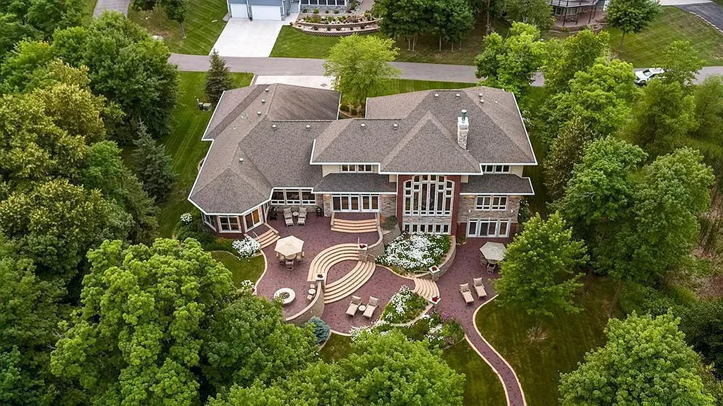This stunning lakefront home is located in Cormorant Park Place, a premier lakeshore community. It has 6 bedrooms, 5 bathrooms, and 9,595 square feet of living space. The home features soaring ceilings, grand windows, hand-hewn imported wood, and hand-picked stone surfaces. It also has a private terrace with a fire pit, and access to the community's amenities, including a clubhouse, heated pool, swim beach, and slip system.