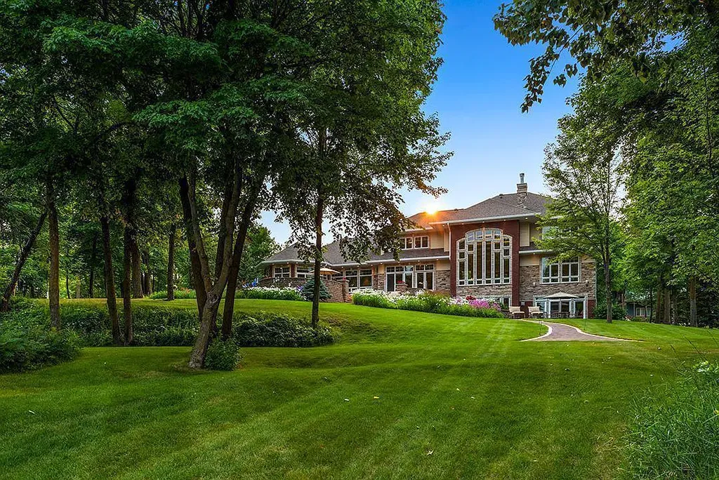 This stunning lakefront home is located in Cormorant Park Place, a premier lakeshore community. It has 6 bedrooms, 5 bathrooms, and 9,595 square feet of living space. The home features soaring ceilings, grand windows, hand-hewn imported wood, and hand-picked stone surfaces. It also has a private terrace with a fire pit, and access to the community's amenities, including a clubhouse, heated pool, swim beach, and slip system.