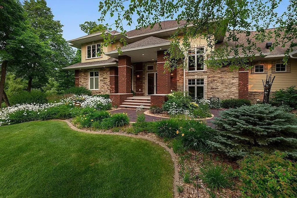 This stunning lakefront home is located in Cormorant Park Place, a premier lakeshore community. It has 6 bedrooms, 5 bathrooms, and 9,595 square feet of living space. The home features soaring ceilings, grand windows, hand-hewn imported wood, and hand-picked stone surfaces. It also has a private terrace with a fire pit, and access to the community's amenities, including a clubhouse, heated pool, swim beach, and slip system.