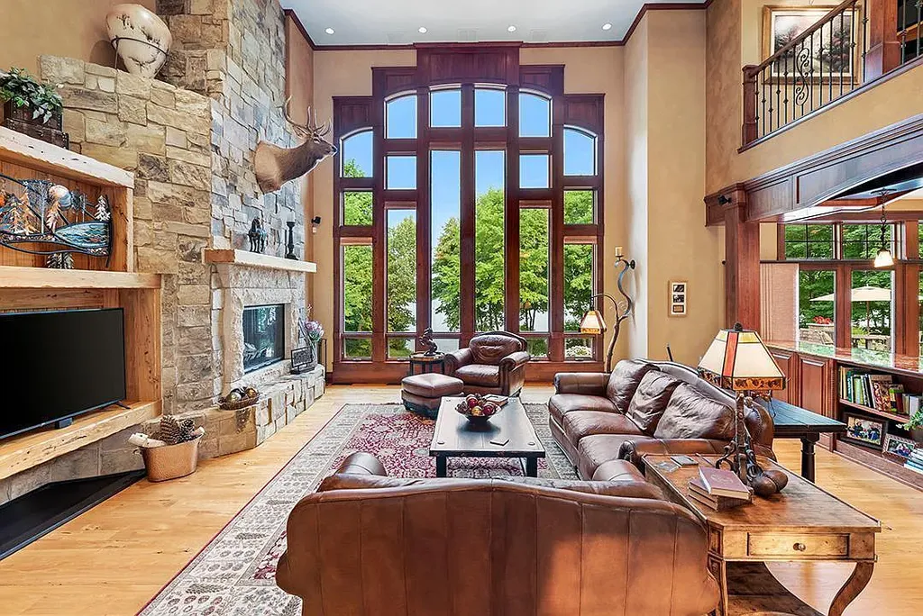 This stunning lakefront home is located in Cormorant Park Place, a premier lakeshore community. It has 6 bedrooms, 5 bathrooms, and 9,595 square feet of living space. The home features soaring ceilings, grand windows, hand-hewn imported wood, and hand-picked stone surfaces. It also has a private terrace with a fire pit, and access to the community's amenities, including a clubhouse, heated pool, swim beach, and slip system.