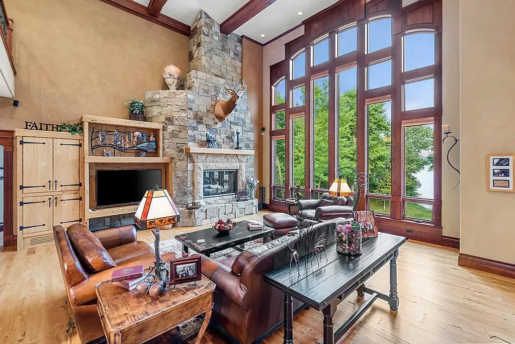 This stunning lakefront home is located in Cormorant Park Place, a premier lakeshore community. It has 6 bedrooms, 5 bathrooms, and 9,595 square feet of living space. The home features soaring ceilings, grand windows, hand-hewn imported wood, and hand-picked stone surfaces. It also has a private terrace with a fire pit, and access to the community's amenities, including a clubhouse, heated pool, swim beach, and slip system.