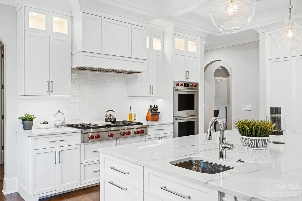 This stunning home in Providence Downs South offers luxury resort living with spa-like amenities, perfect for entertaining and relaxing. It has 5 bedrooms, 4 full baths, and 3 half baths, plus a 4-car garage with epoxy floor. The kitchen has a huge island with Wolf & Subzero appliances, and the backyard has a heated pool, hot tub, and pool house with sauna. 
