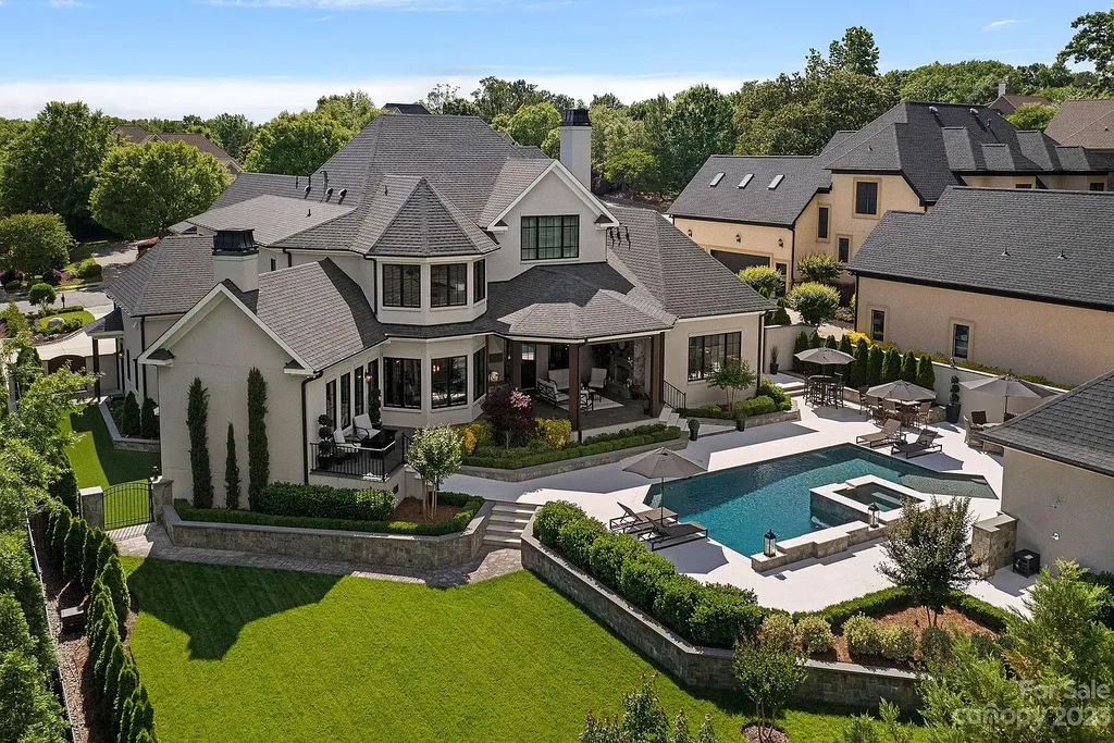 This stunning home in Providence Downs South offers luxury resort living with spa-like amenities, perfect for entertaining and relaxing. It has 5 bedrooms, 4 full baths, and 3 half baths, plus a 4-car garage with epoxy floor. The kitchen has a huge island with Wolf & Subzero appliances, and the backyard has a heated pool, hot tub, and pool house with sauna. 