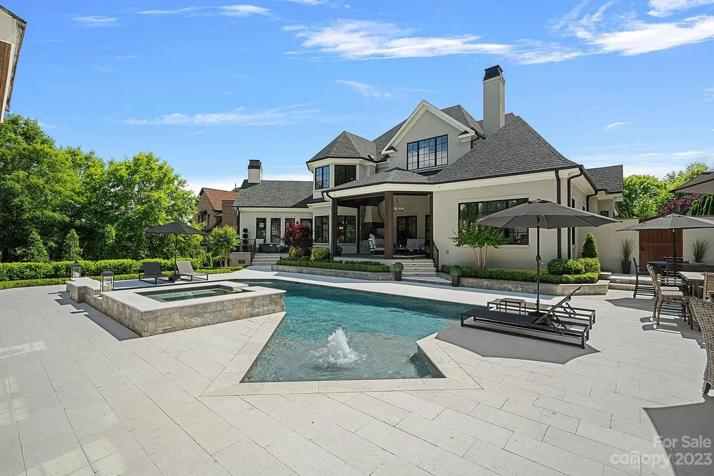This stunning home in Providence Downs South offers luxury resort living with spa-like amenities, perfect for entertaining and relaxing. It has 5 bedrooms, 4 full baths, and 3 half baths, plus a 4-car garage with epoxy floor. The kitchen has a huge island with Wolf & Subzero appliances, and the backyard has a heated pool, hot tub, and pool house with sauna. 