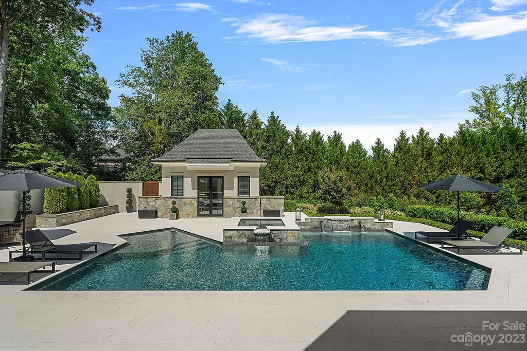 This stunning home in Providence Downs South offers luxury resort living with spa-like amenities, perfect for entertaining and relaxing. It has 5 bedrooms, 4 full baths, and 3 half baths, plus a 4-car garage with epoxy floor. The kitchen has a huge island with Wolf & Subzero appliances, and the backyard has a heated pool, hot tub, and pool house with sauna. 