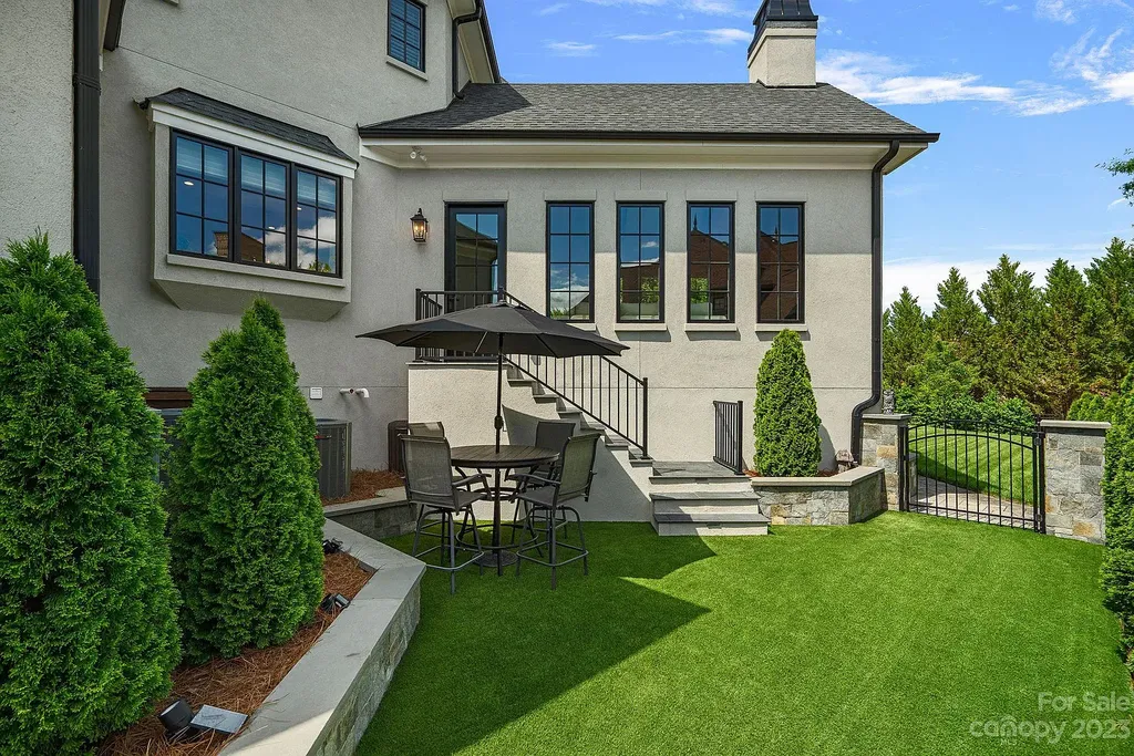 This stunning home in Providence Downs South offers luxury resort living with spa-like amenities, perfect for entertaining and relaxing. It has 5 bedrooms, 4 full baths, and 3 half baths, plus a 4-car garage with epoxy floor. The kitchen has a huge island with Wolf & Subzero appliances, and the backyard has a heated pool, hot tub, and pool house with sauna. 