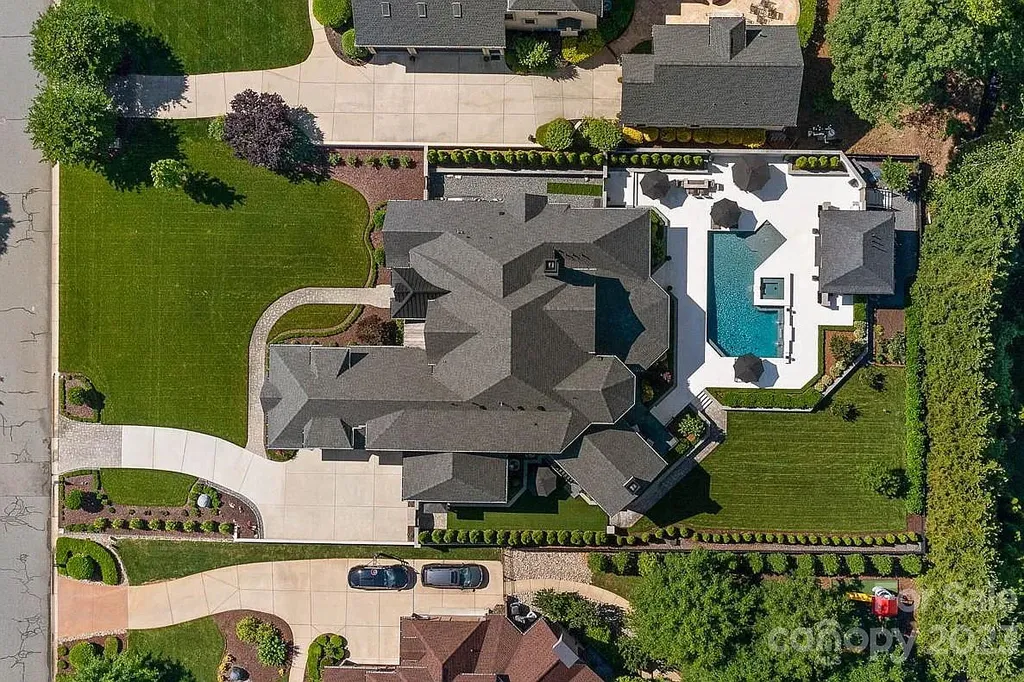This stunning home in Providence Downs South offers luxury resort living with spa-like amenities, perfect for entertaining and relaxing. It has 5 bedrooms, 4 full baths, and 3 half baths, plus a 4-car garage with epoxy floor. The kitchen has a huge island with Wolf & Subzero appliances, and the backyard has a heated pool, hot tub, and pool house with sauna. 