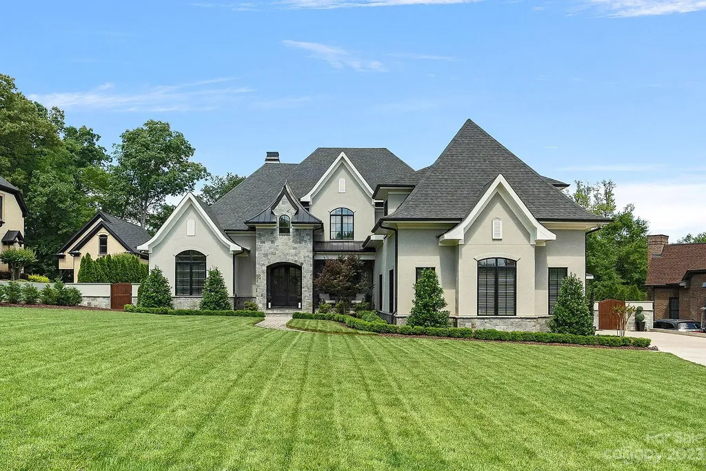 This stunning home in Providence Downs South offers luxury resort living with spa-like amenities, perfect for entertaining and relaxing. It has 5 bedrooms, 4 full baths, and 3 half baths, plus a 4-car garage with epoxy floor. The kitchen has a huge island with Wolf & Subzero appliances, and the backyard has a heated pool, hot tub, and pool house with sauna. 