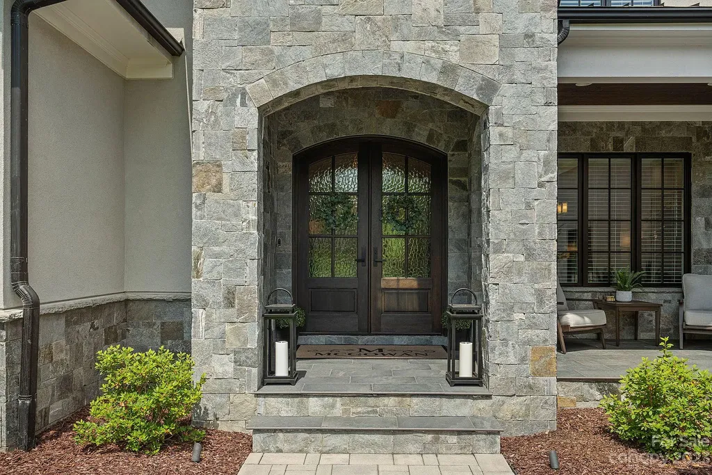 This stunning home in Providence Downs South offers luxury resort living with spa-like amenities, perfect for entertaining and relaxing. It has 5 bedrooms, 4 full baths, and 3 half baths, plus a 4-car garage with epoxy floor. The kitchen has a huge island with Wolf & Subzero appliances, and the backyard has a heated pool, hot tub, and pool house with sauna. 