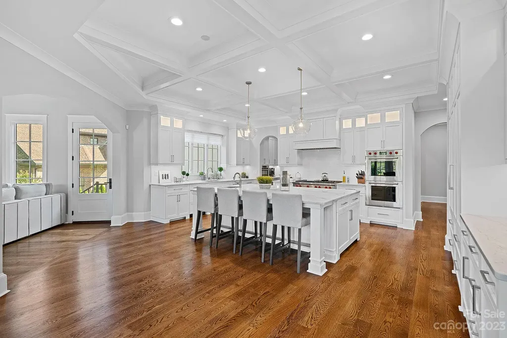 This stunning home in Providence Downs South offers luxury resort living with spa-like amenities, perfect for entertaining and relaxing. It has 5 bedrooms, 4 full baths, and 3 half baths, plus a 4-car garage with epoxy floor. The kitchen has a huge island with Wolf & Subzero appliances, and the backyard has a heated pool, hot tub, and pool house with sauna. 