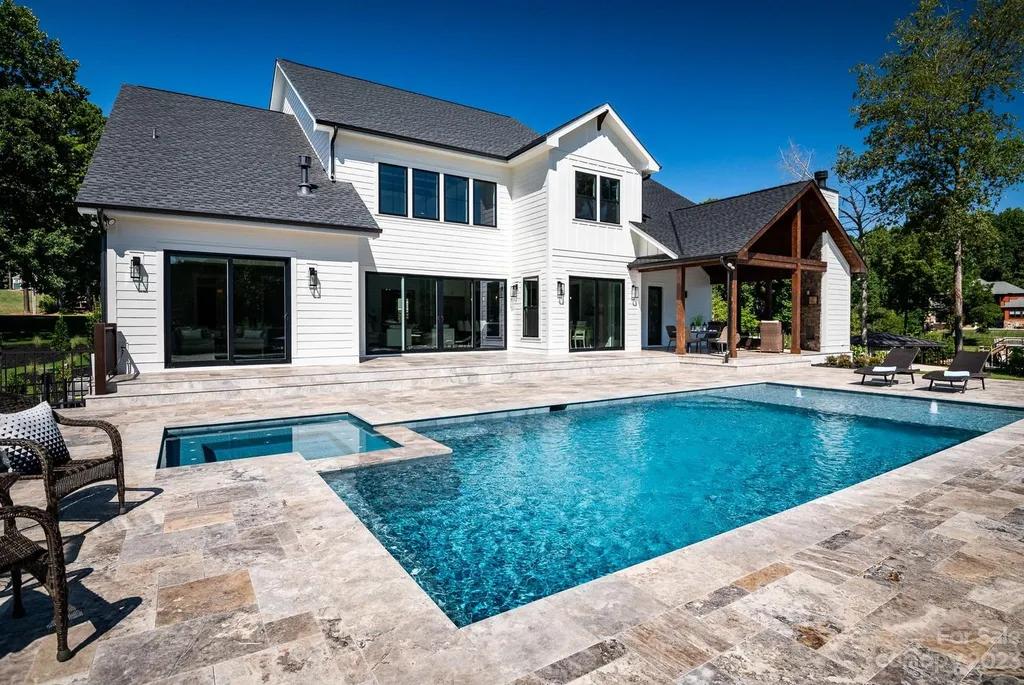 155 Riverwood Road Home in Mooresville, North Carolina. Experience the epitome of luxury in this new construction home on Lake Norman. Boasting 4 bedrooms, 4.5 bathrooms, a pool, dock, and breathtaking lake views, this home offers a lifestyle of comfort and elegance. 