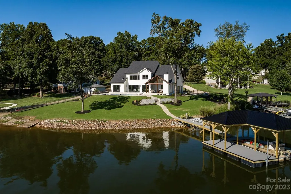 155 Riverwood Road Home in Mooresville, North Carolina. Experience the epitome of luxury in this new construction home on Lake Norman. Boasting 4 bedrooms, 4.5 bathrooms, a pool, dock, and breathtaking lake views, this home offers a lifestyle of comfort and elegance. 